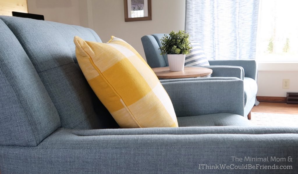 minimalist living room, blue chair, yellow throw pillow